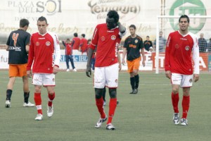 Los deportivistas Pierre, Diop y Raúl Rodríguez se van a los vestuarios tras consumarse el descenso del Eivissa a Tercera División.  JUAN A. RIERA