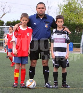 El colegiado con los dos capitanes del partido