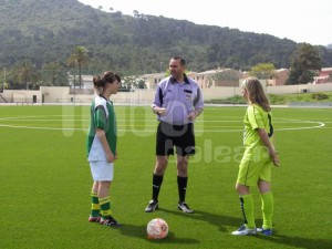 El colegiado con las capitanas durante el sorteo de campo