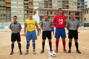 El colegiado con los asistentes y capitanes del partido