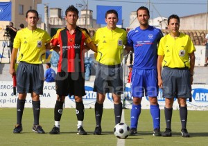 El colegiado con los capitanes y asistentes del partido