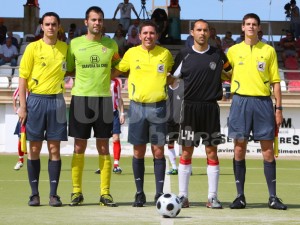 El colegiado con los capitanes y asistentes del partido