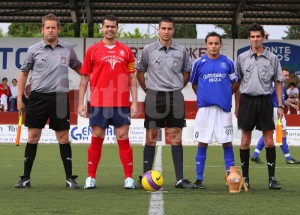 El colegiado con los capitanes y asistentes del partido