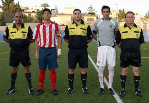 El trio arbitral con los capitanes del partido