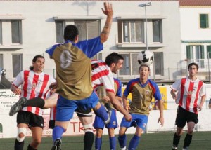 Óscar despeja. El central mercadalense saca un balón con la cabeza ante la oposición de Héctor