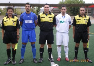 El trío arbitral con los capitanes del partido