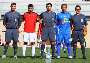 El trio arbitral con los capitanes del partido