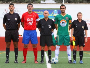 El trío arbitral con los capitanes del partido