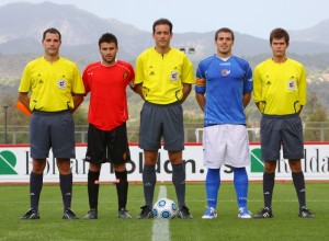 El trío arbitral con los capitanes del partido