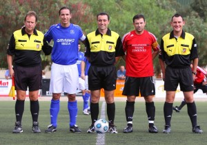 El trío arbitral con los capitanes del partido