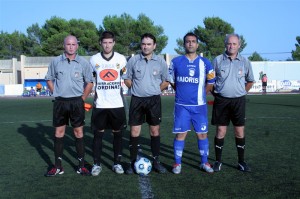 El trio arbitral con los capitanes del partido.