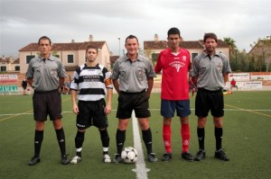 El trio arbitral con los capitanes del partido