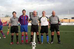 El trío arbitral con los capitanes del partido