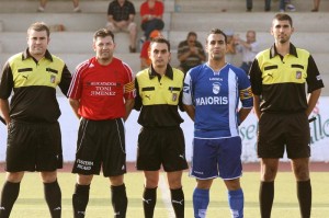 El trío arbitral con los capitanes del partido