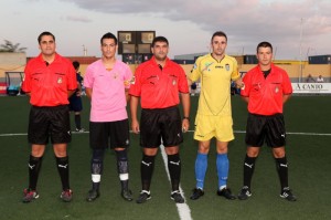 El trio arbitral con los capitanes del partido