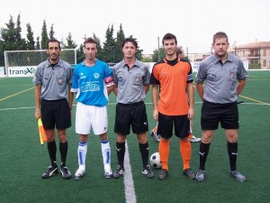 El trio arbitral con los capitanes del partido