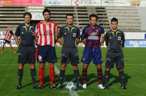 El trío arbitral con los capitanes del partido