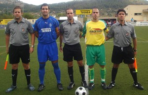 El trio arbitral con los capitanes del partido