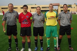 El trio arbitral con los capitanes del partido