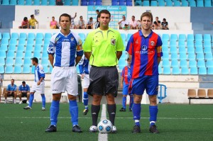 El colegiado con los capitanes del partido