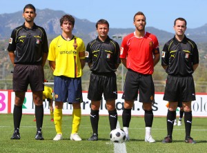 El trio arbitral con los capitanes del partido