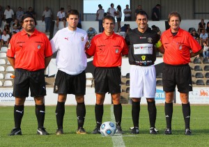 El trio arbitral con los capitanes del partido