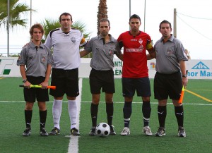 El trio arbitral con los capitanes del partido