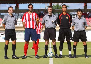 El trío arbitral con los capitanes del partido