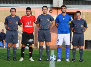 El trio arbitral con los capitanes del partido