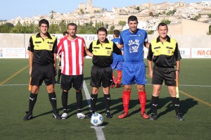 El trio arbitral con los capitanes del partido