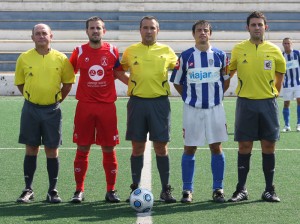 El trio arbitral con los capitanes del partido