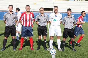 El trío arbitral con los capitanes del partido