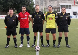 El trío arbitral con los capitanes del partido