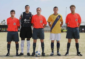 El trío arbitral con los capitanes del partido