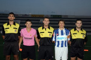 El trío arbitral con los capitanes del partido