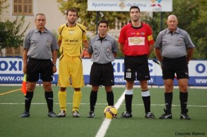 El trío arbitral con los capitanes del partido