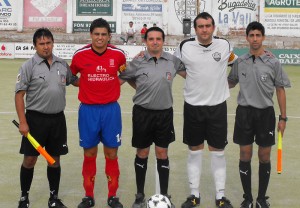 El trio arbitral con los capitanes del partido