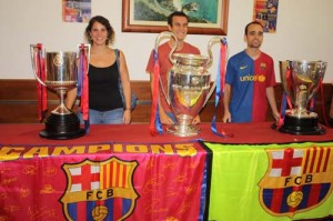 Foto para el recuerdo. Los aficionados azulgranas de Ciutadella posaron ante los trofeos de Copa del Rey, Liga y Champions