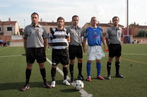 El trio arbitral con los capitanes del partido