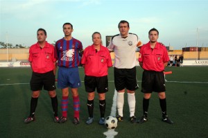 El trio arbitral con los capitanes del partido