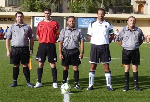 El trio arbitral con los capitanes del partido