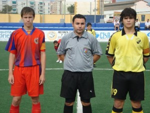 El colegiado con los capitanes del partido