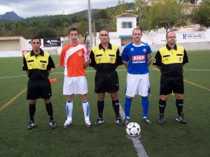 El trio arbitral con los capitanes del partido