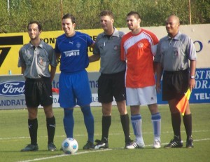 El trio arbitral con los capitanes del partido