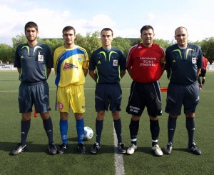 El trio arbitral con los capitanes del partido