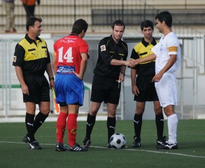 El trio arbitral con los capitanes del partido