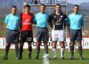 El trío arbitral con los capitanes del partido