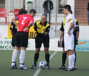 El arbitro del partido en el sorteo con los capitanes.