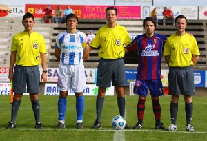 El Trio arbitral con los capitanes del partido.