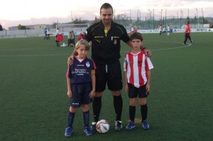 El colegiado con los capitanes del partido